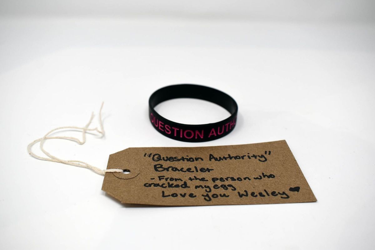 The image shows a "Question Authority" bracelet and tag with a personal message from Wesley.