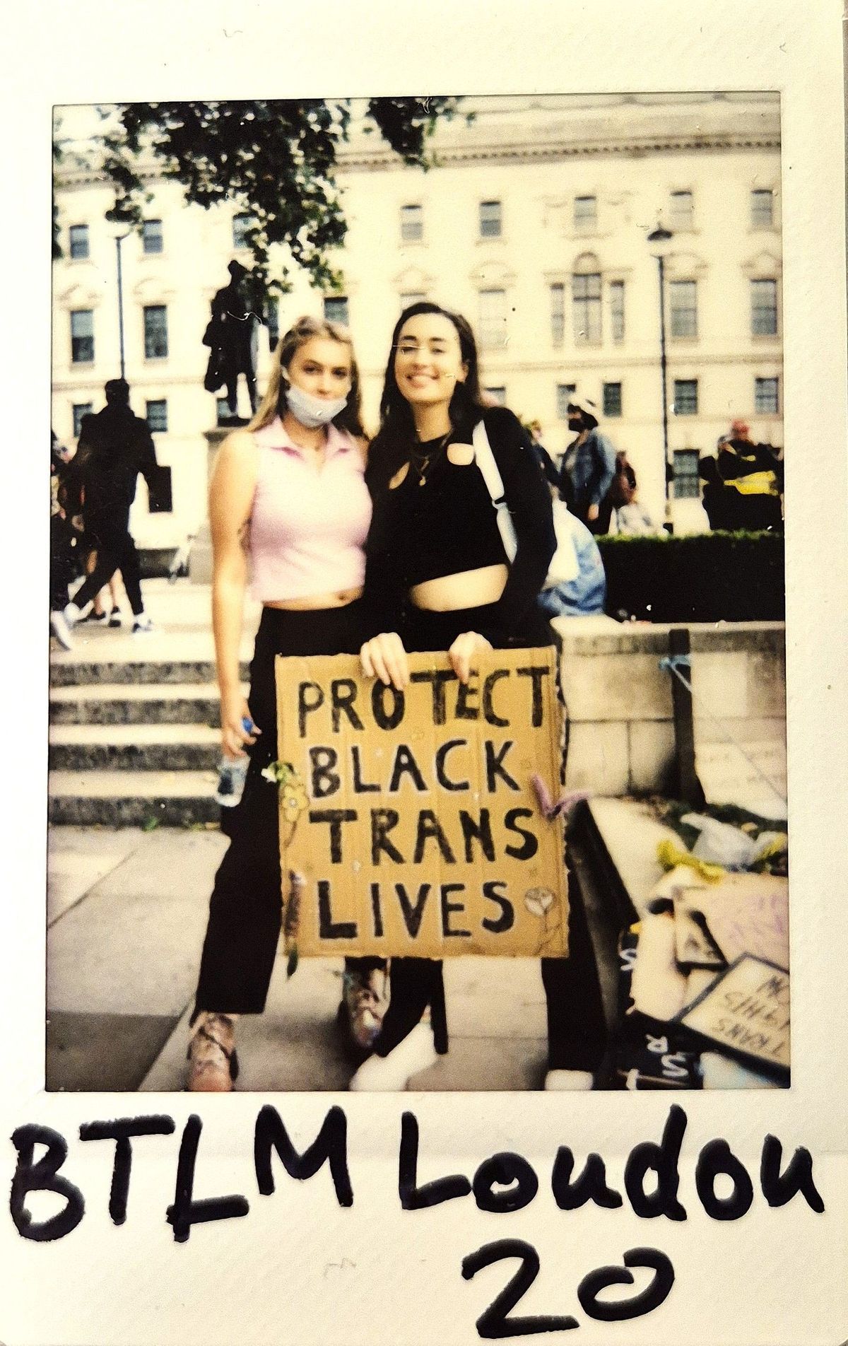 Two people stand together holding a sign that reads "Protect Black Trans Lives," at a demonstration in London,