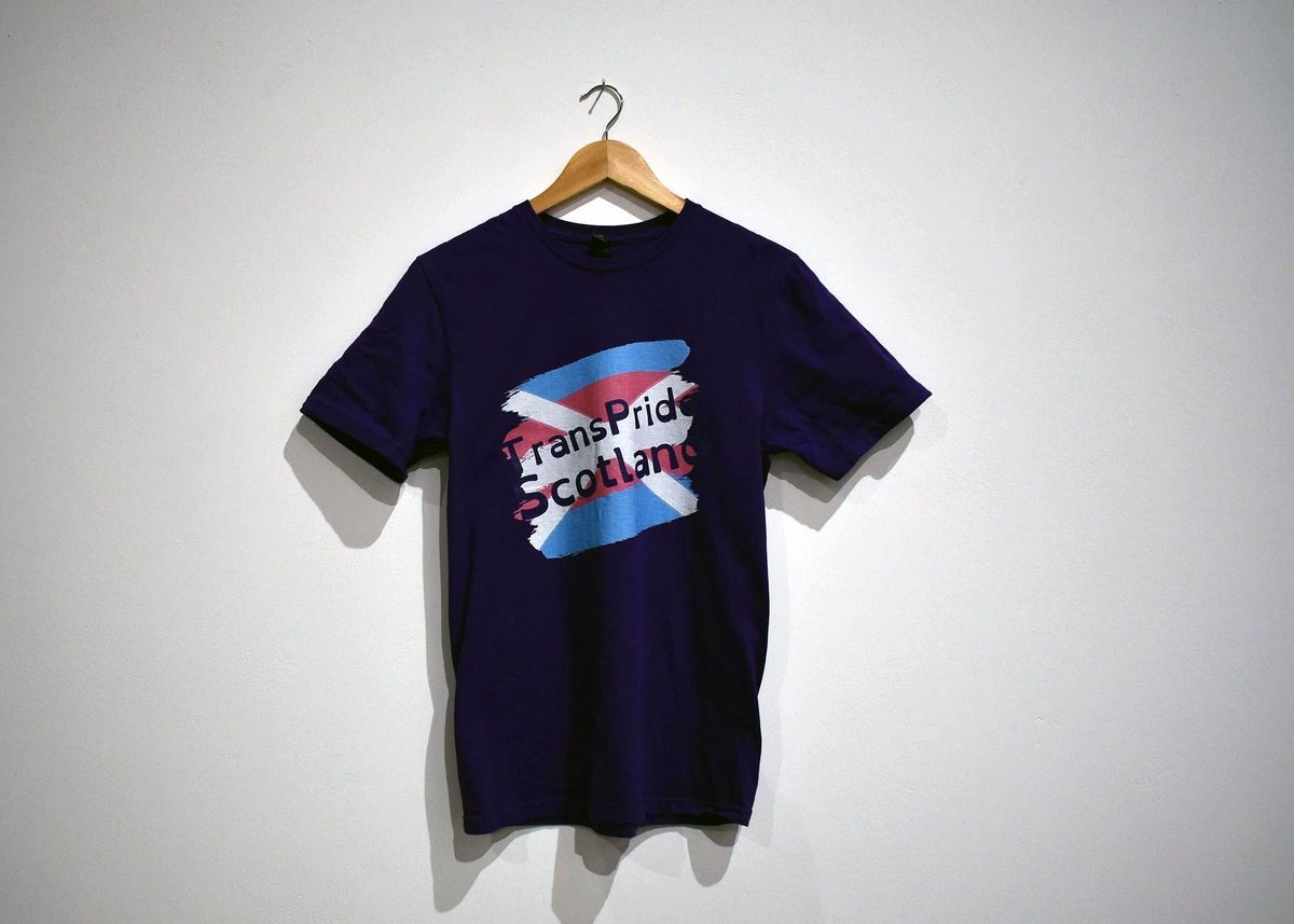 A t-shirt which is a navy blue and has a UK flag on the front which says 'Trans Pride Scotland'.