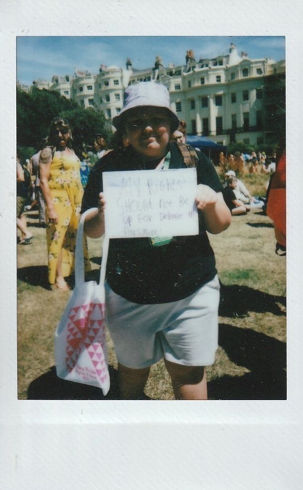 A person holds a sign saying "My rights should not be up for debate".