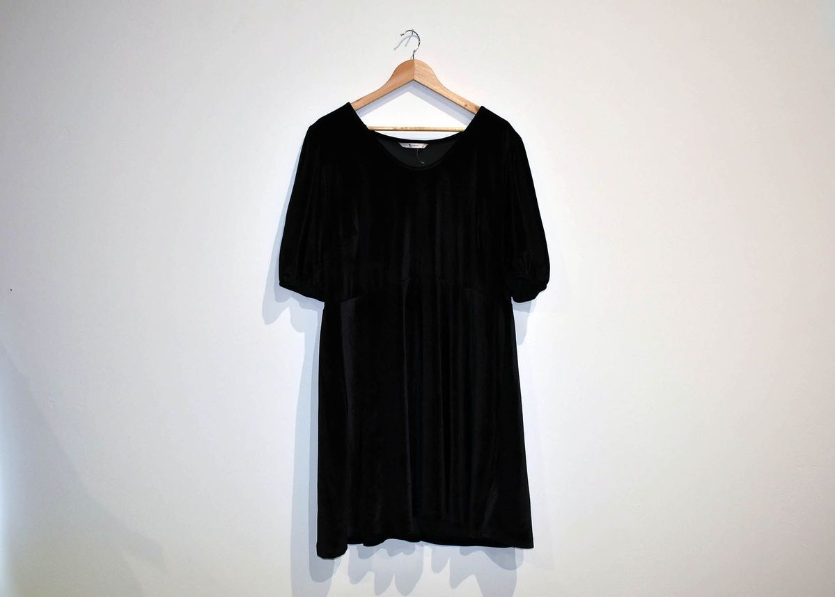 A black dress on a wooden hanger.