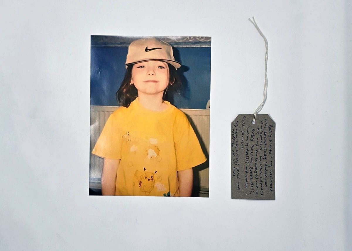 A photo of a child wearing a Nike baseball cap and a yellow Pokemon t-shirt. With a brown handwritten luggage tag.