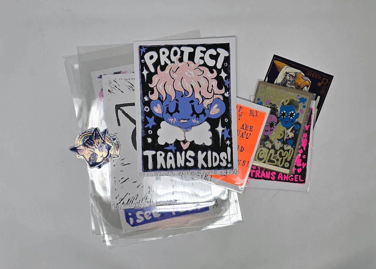 A selection of lino prints, postcards and stickers that are lay on top of each other.