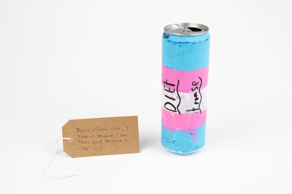 A colorful can painted in blue, pink, and white with handwritten labels on it.