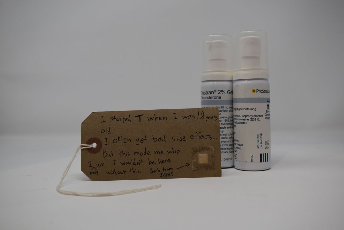 This image shows two Tostran testosterone 2% gel pump dispensers with a brown tag with handwritten text on it in front.