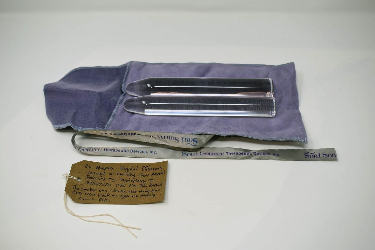 Two clear perspex dilators on a purple cloth bag, with a Soul Source ribbon and a brown, handwritten luggage tag.