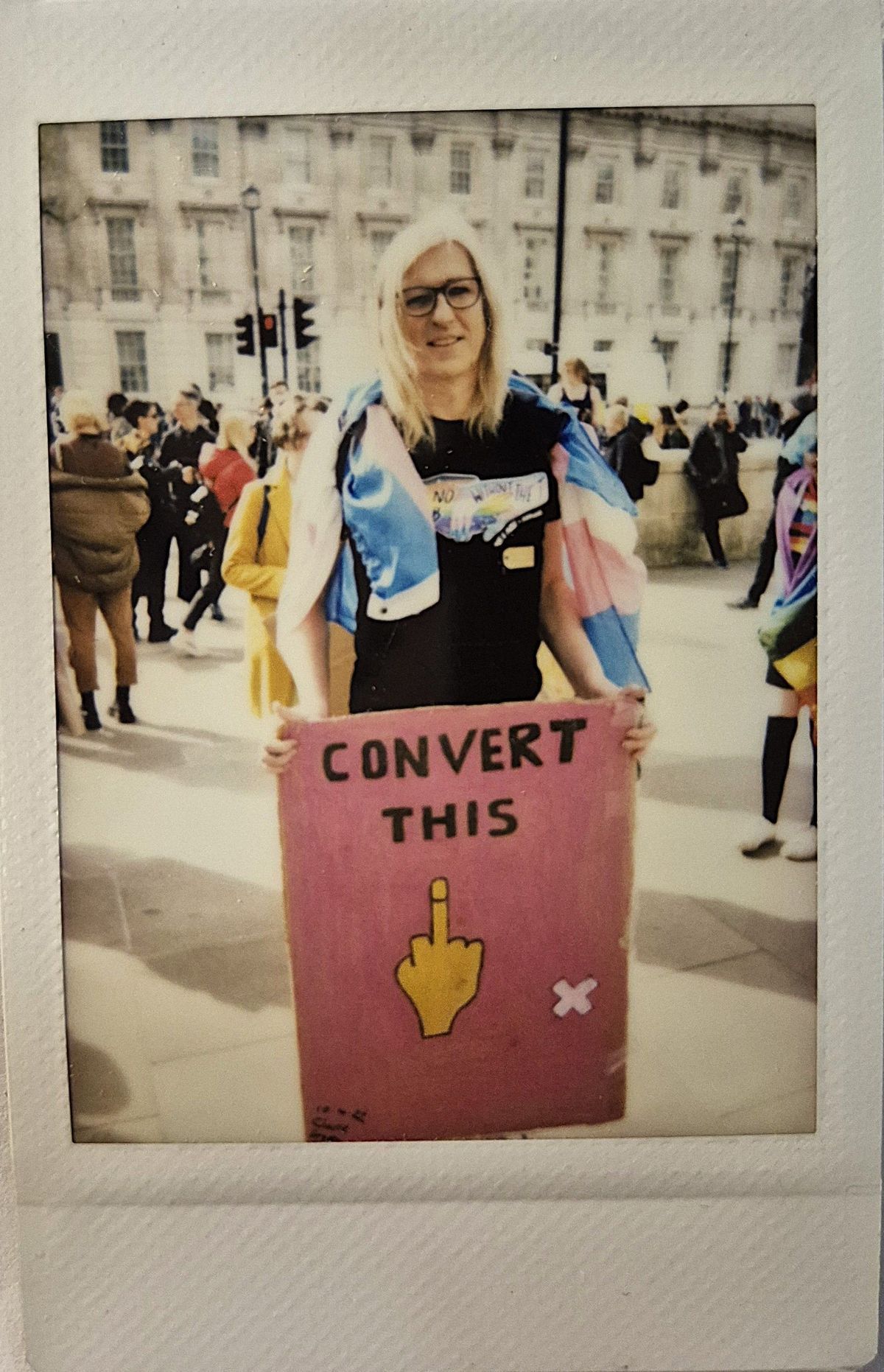 A person holding a sign that says “CONVERT THIS” with a middle finger gesture.