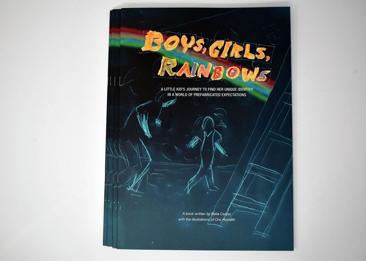 Dark blue pamphlet with light blue sketch of two people walking and a ladder. There is a rainbow across the top and the words "BOYS, GIRLS, RAINBOWS" above "A LITTLE KID'S JOURNEY TO FIND HER UNIQUE IDENTITY IN A WORLD OF PREFABRICATED EXPECTATIONS". At the bottom it says "A book written by Reka Csahyi with the illustrations of Orsi Horvath"