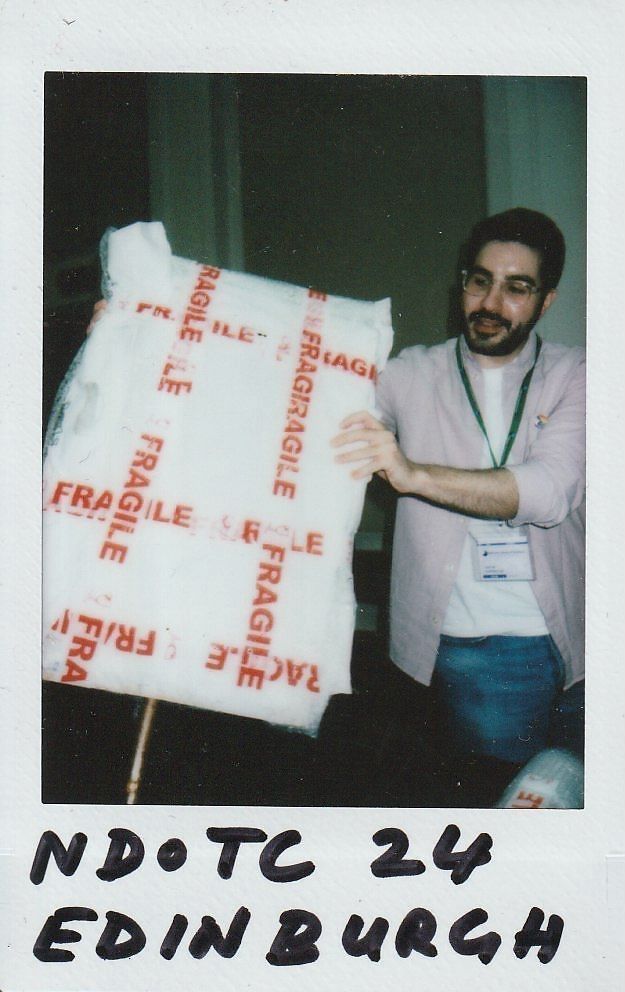 A man is carefully holding a package labeled "fragile".