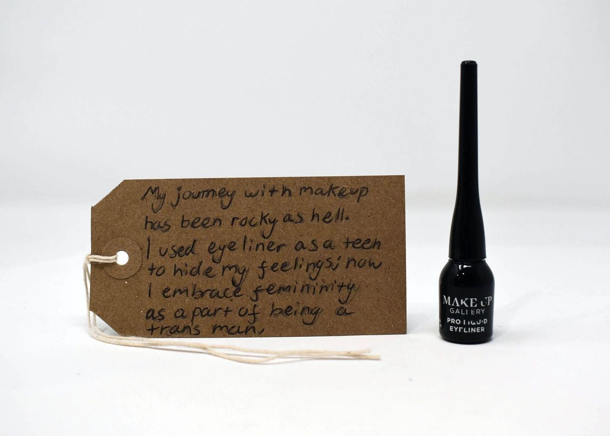 A black eyeliner and a brown luggage tag with writing on it.