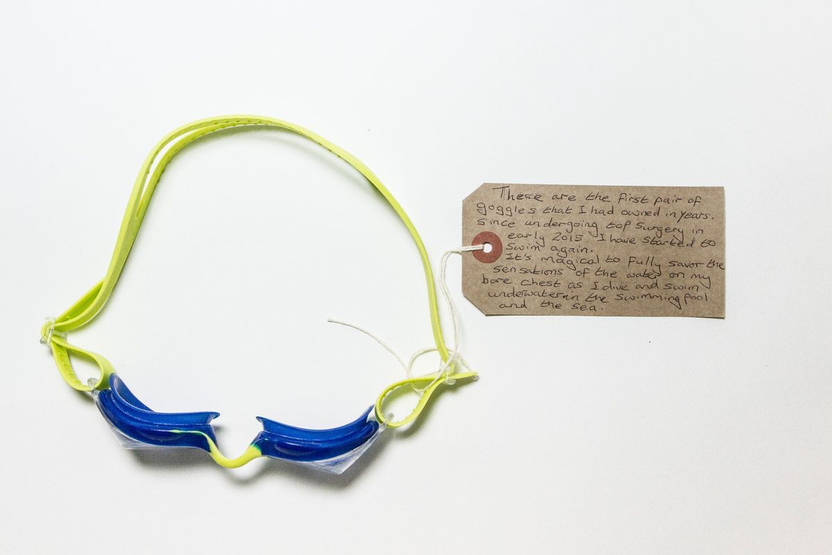 A pair of goggles with a lime green band, navy blue rims, and clear lenses.