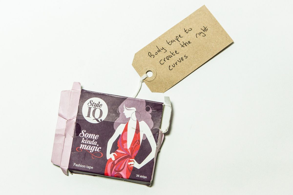 Black box showing white figure wearing pink dress. Box reads "Style IQ" and has some rips.