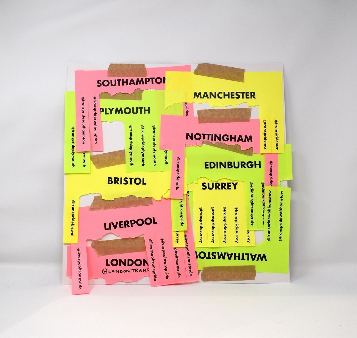 The image shows colorful city names on paper with tape, including London and Manchester.