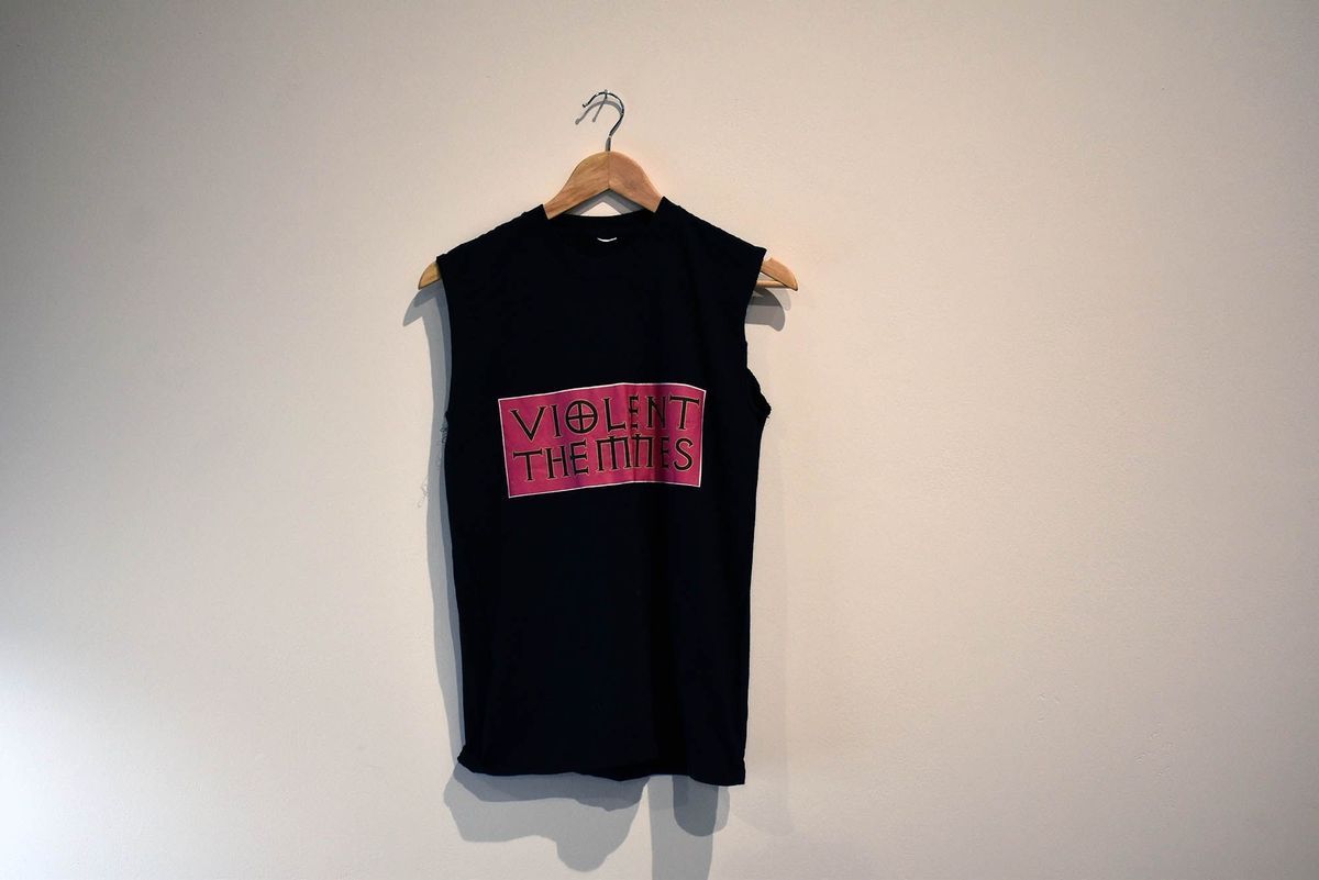 A black sleeveless T-shirt with "VIOLENT THEMMES" in pink text.