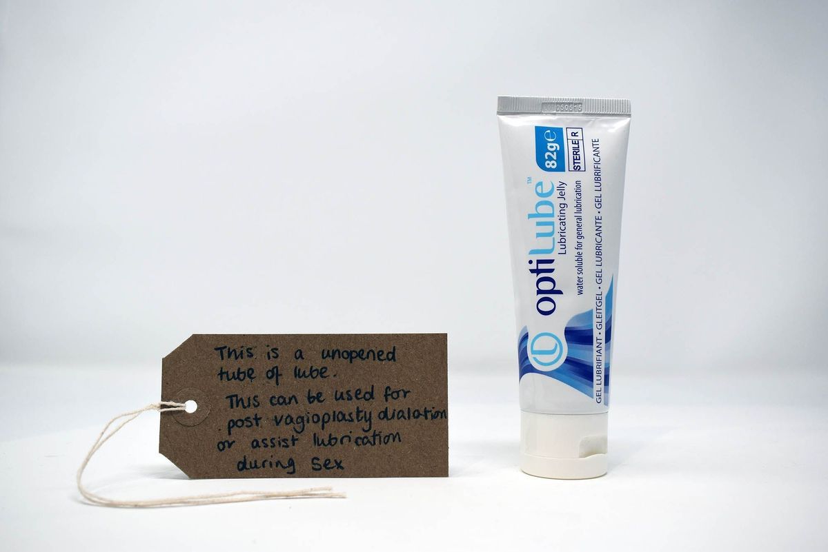 White tube with blue lettering reading "optiLube Lubricating Jelly"