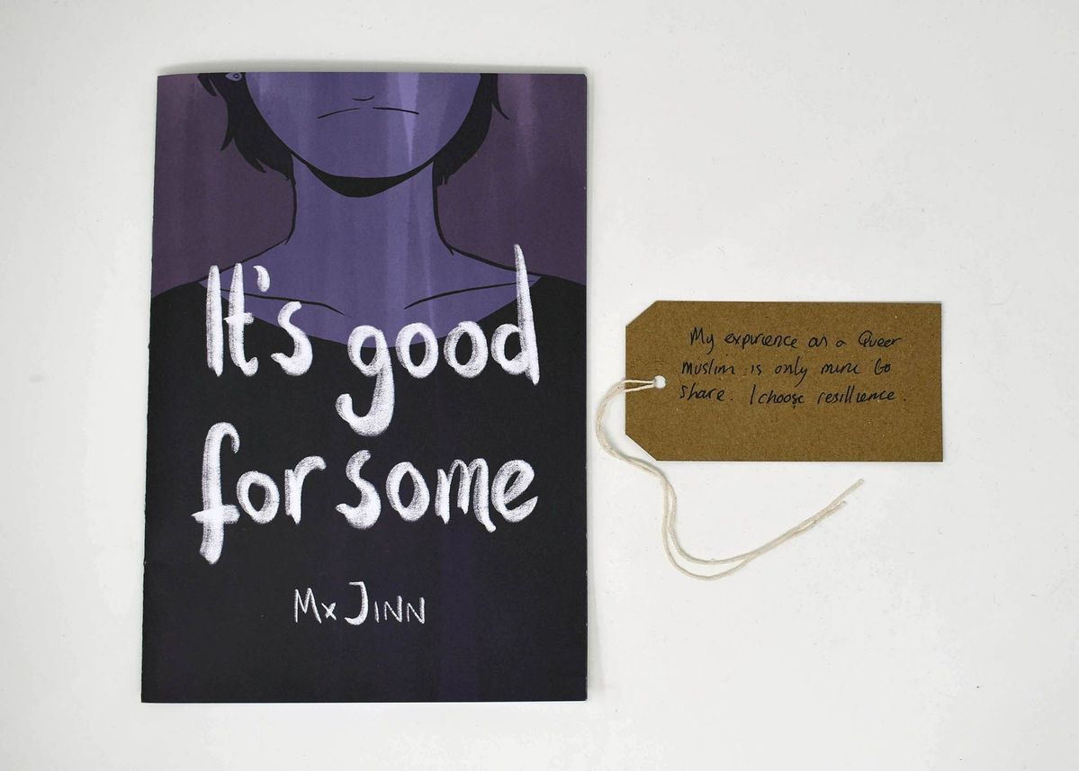A comic book entitled "It's good for some" by Mx Jinn. The cover is purple and features the lower face and upper body of a person. With a brown, handwritten luggage tag.