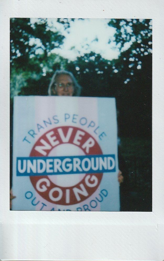 A person holds a placard which says "Trans People Are Never Going Underground".