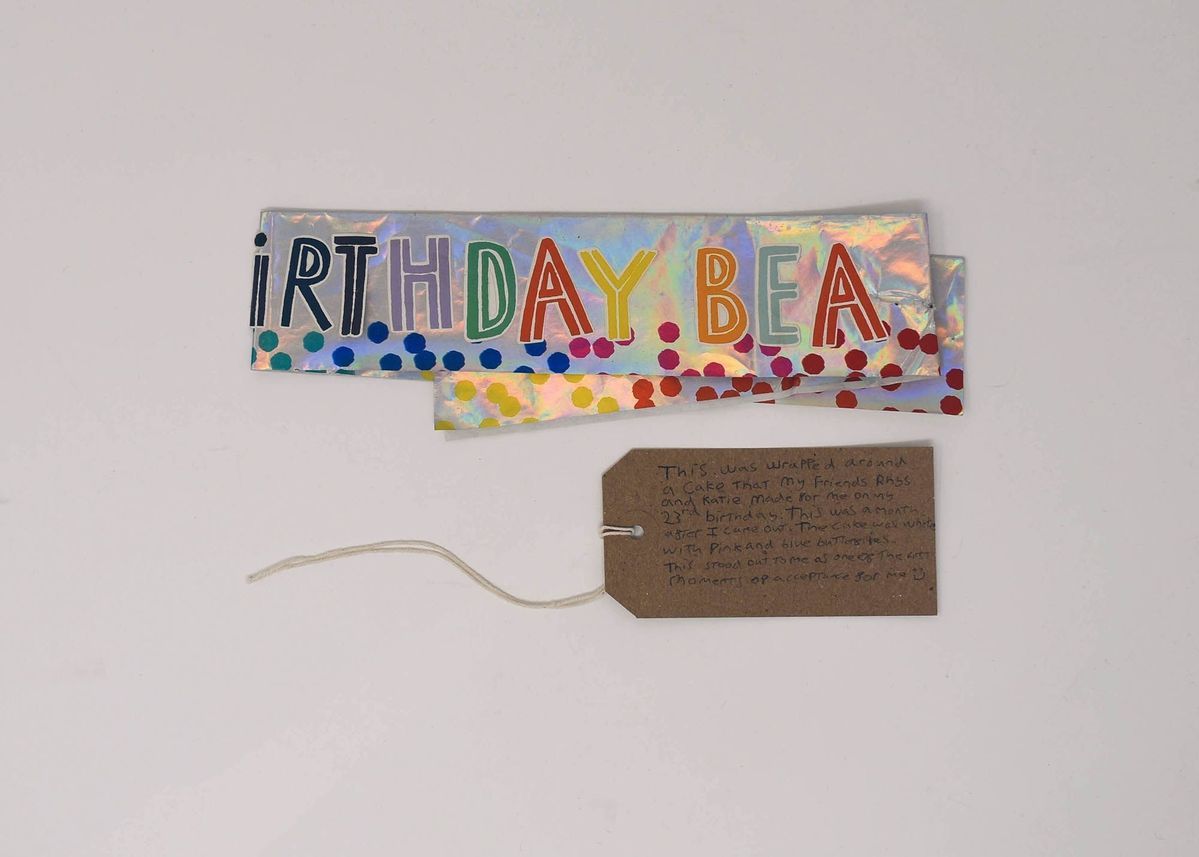 A silver birthday banner which is colourful and says 'Birthday'.