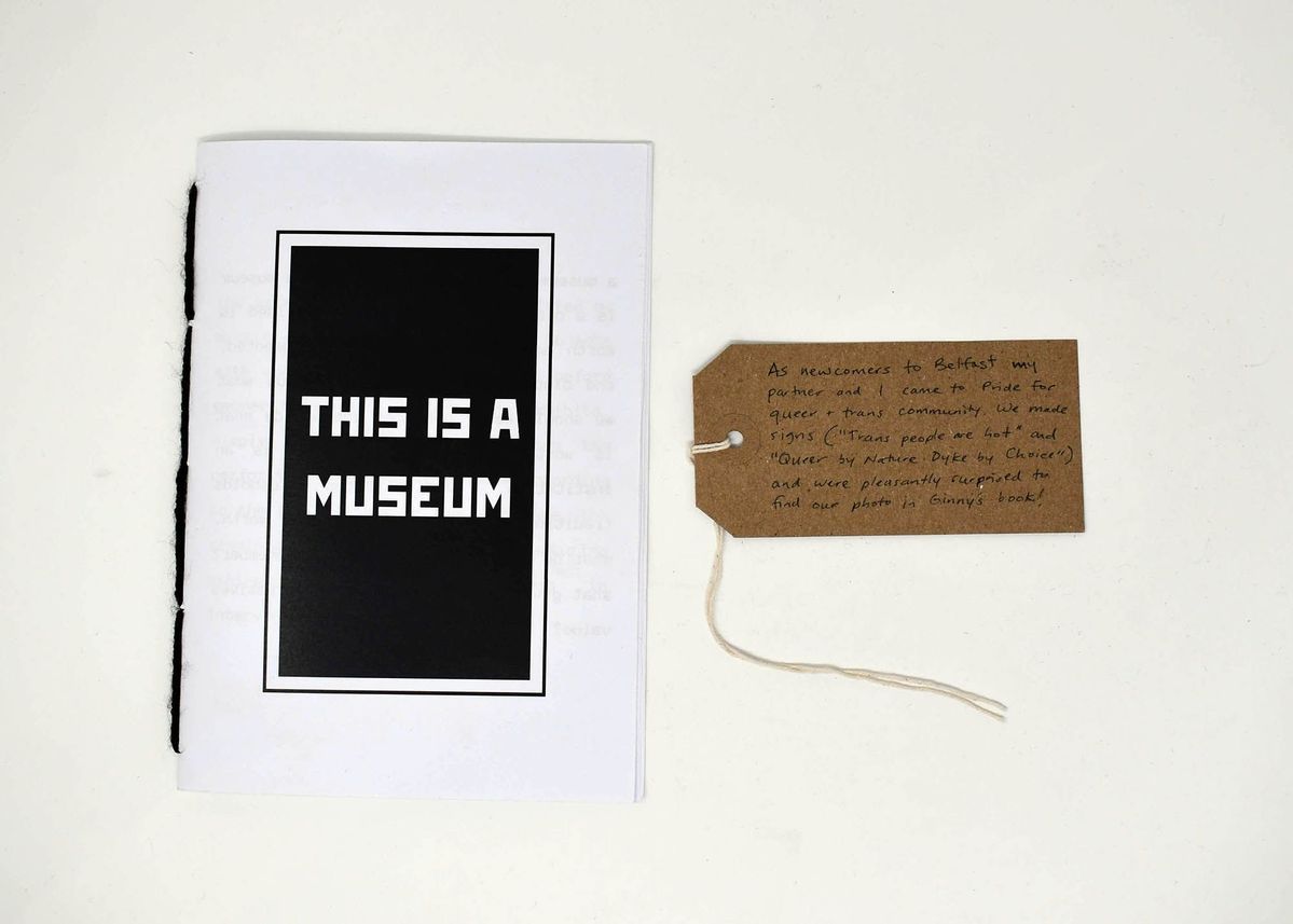 The image shows a booklet titled "THIS IS A MUSEUM" next to a handwritten tag.