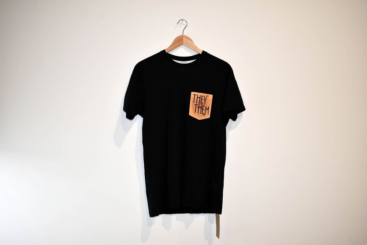 Black t-shirt with they them print on breast pocket.