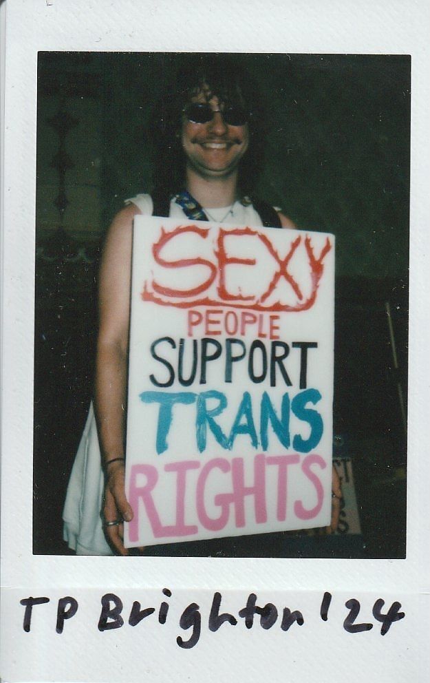 A person holds a sign that reads, "Sexy people support trans rights," expressing solidarity with the trans community.