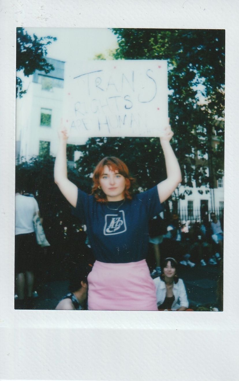 A person holds a sign reading “Trans rights are human rights” during a protest.