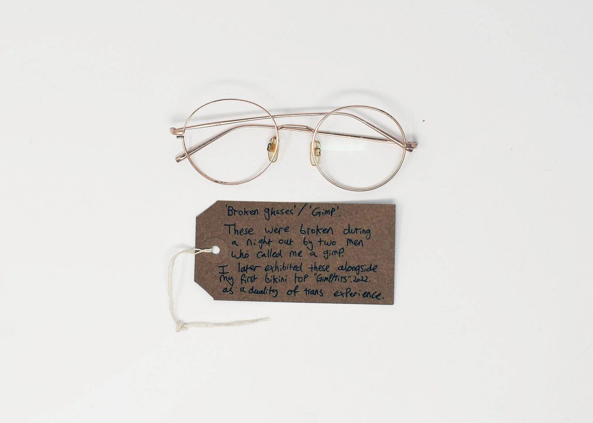 A pair of broken glasses lies above a handwritten note, recounting their damaging incident.