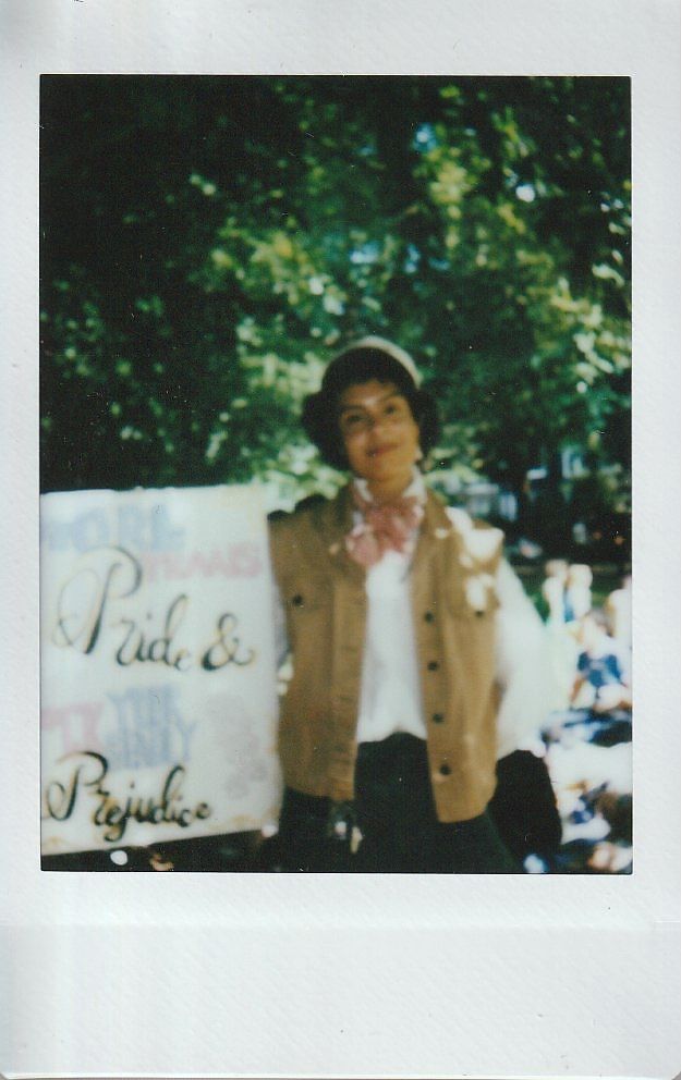 A person holds a placard which says "Pride & Prejudice".
