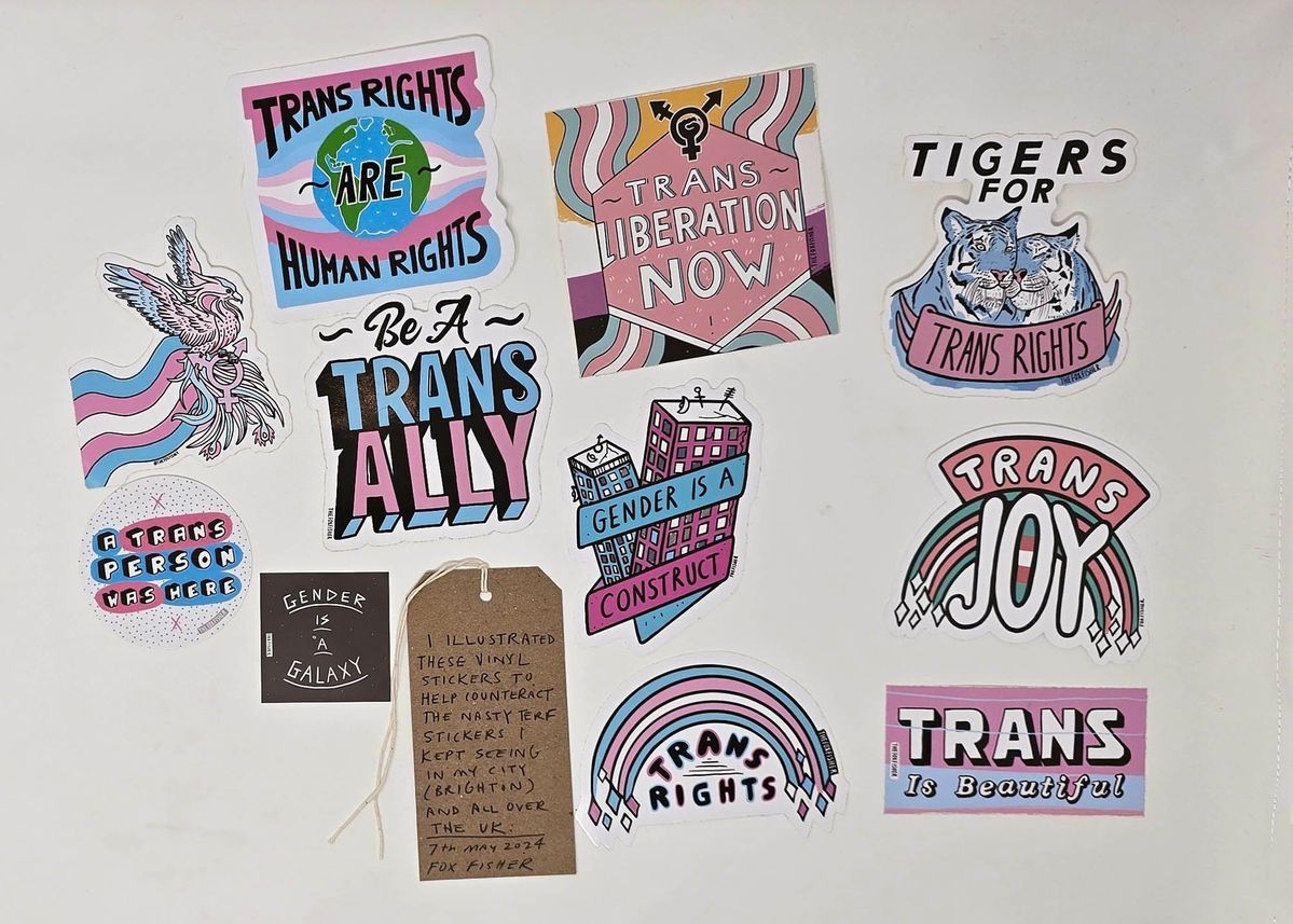 The image features colorful stickers advocating for transgender rights with supportive messages and imagery.