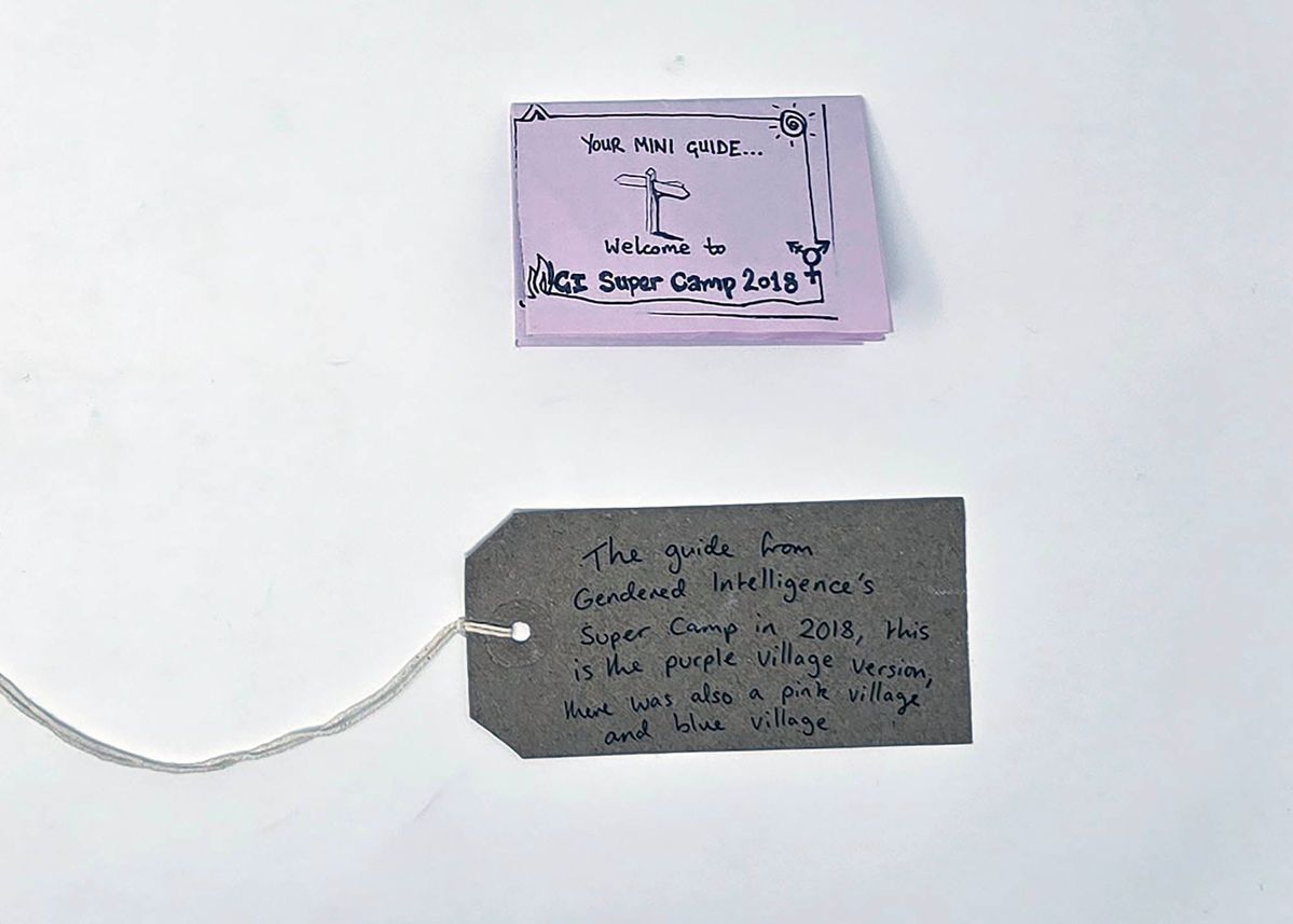 Gendered Intelligence Super Camp 2018 Mini Guide booklet printed on pink paper. Also, a brown handwritten luggage tag.