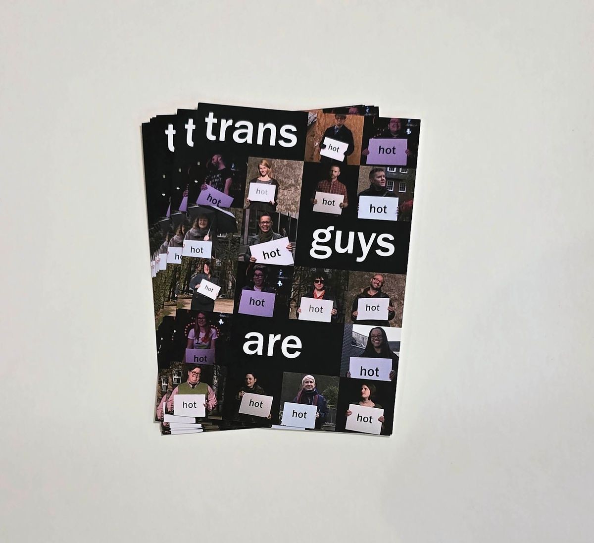 The image features a collage of people holding signs reading "hot" with the text "trans guys are hot'.