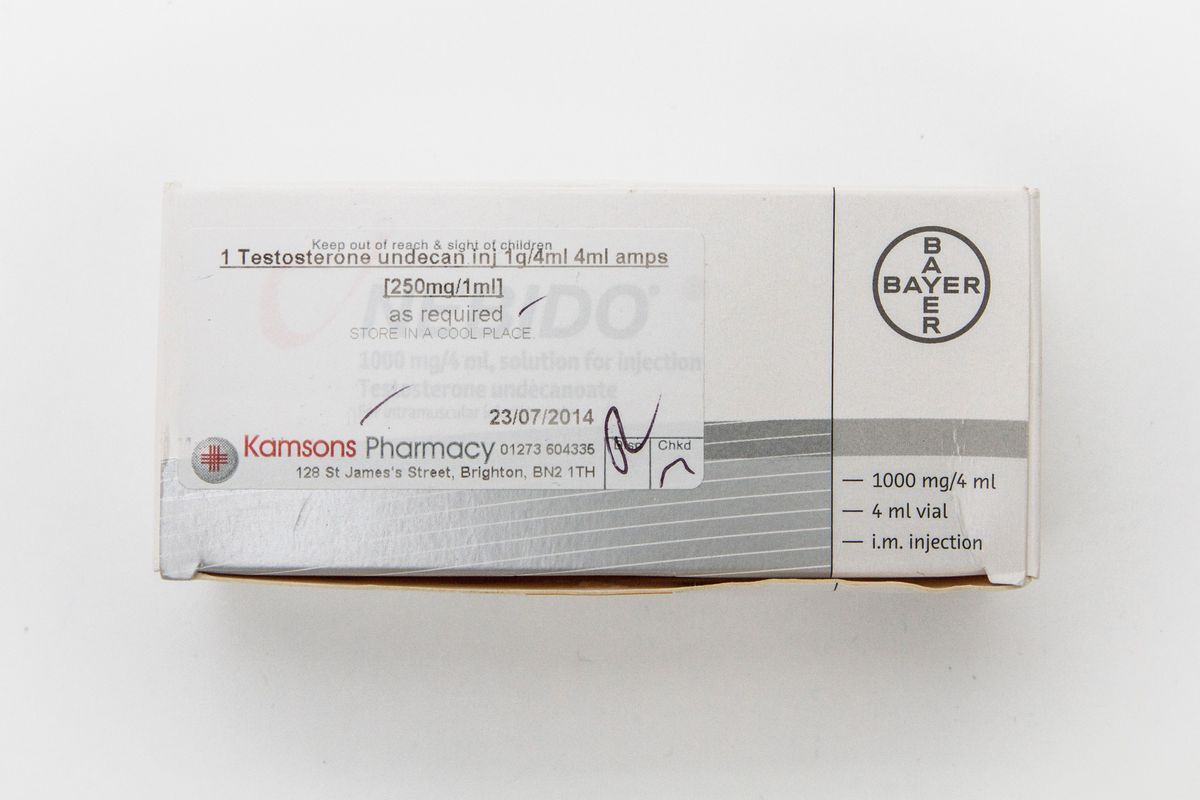 Box for "Nebido" testosterone ampoules sitting on a wooden surface. There is a faded label for Kamsons Pharmacy stuck to the top.