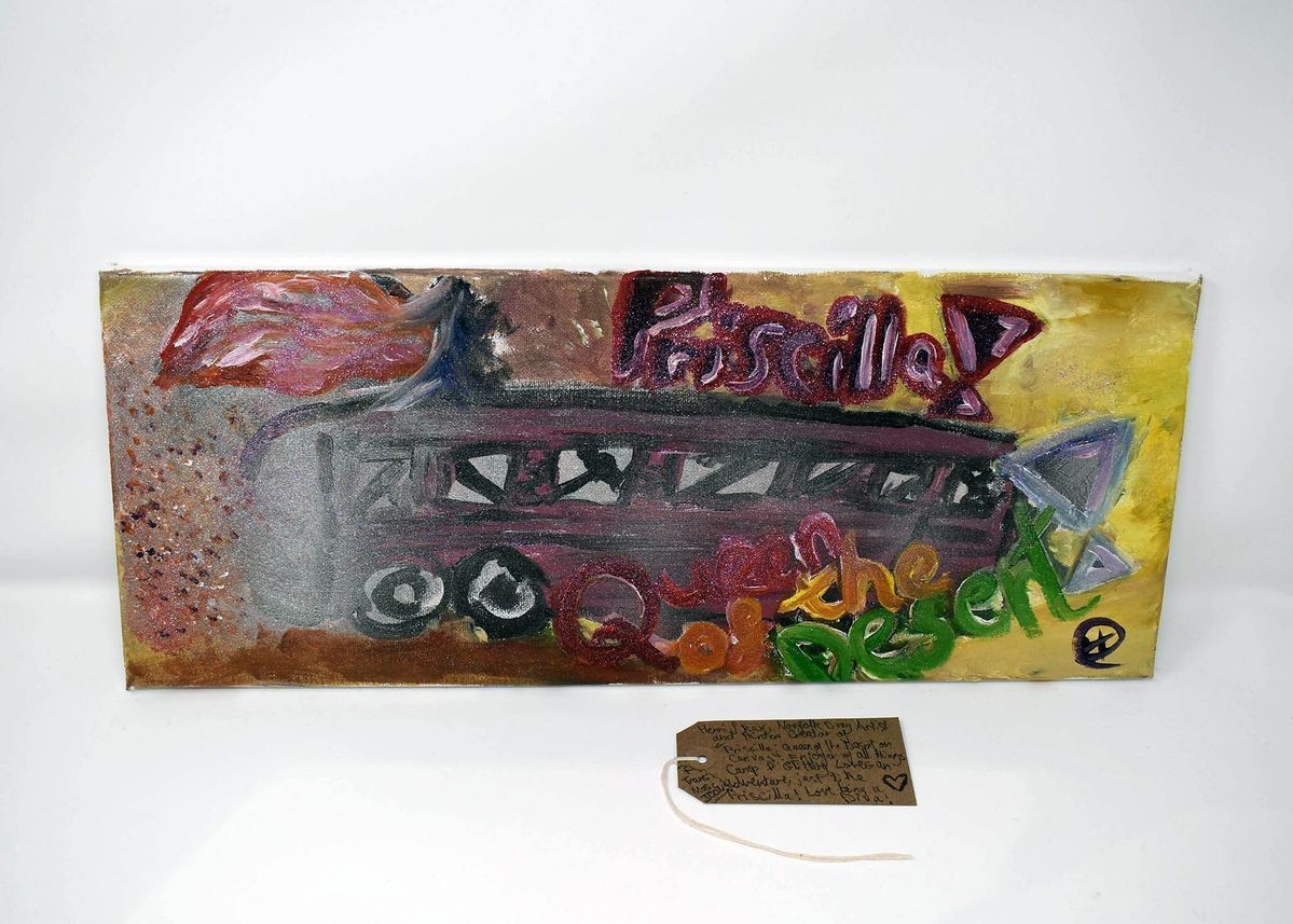 A colourful paining which says 'Priscilla Queen of the Desert'