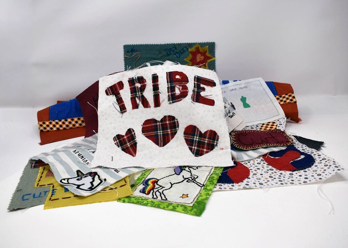 The image features diverse fabric patches with designs, including "TRIBE" and hearts.
