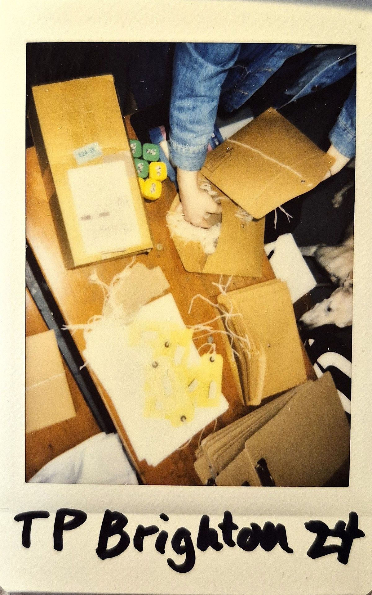 A table which is full and busy of peoples hands packing with labels.