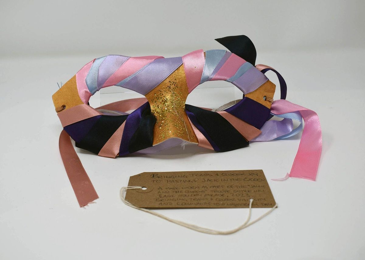 A mask which is wrapped in many different colours of fabric.