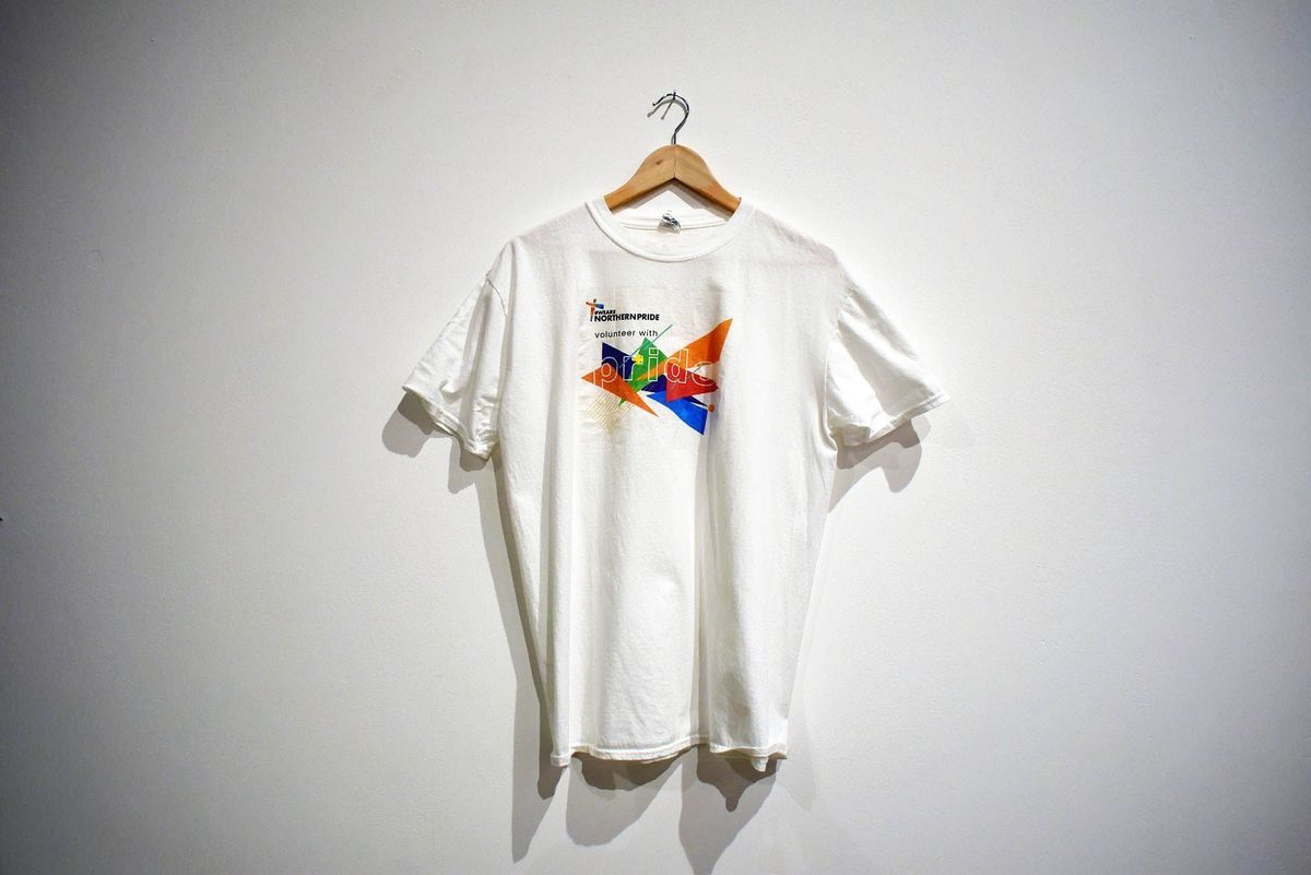 A white t-shirt on a wooden hanger with a colourful logo and txt "#WEARE NORTHERNPRIDE" "volunteer with pride".