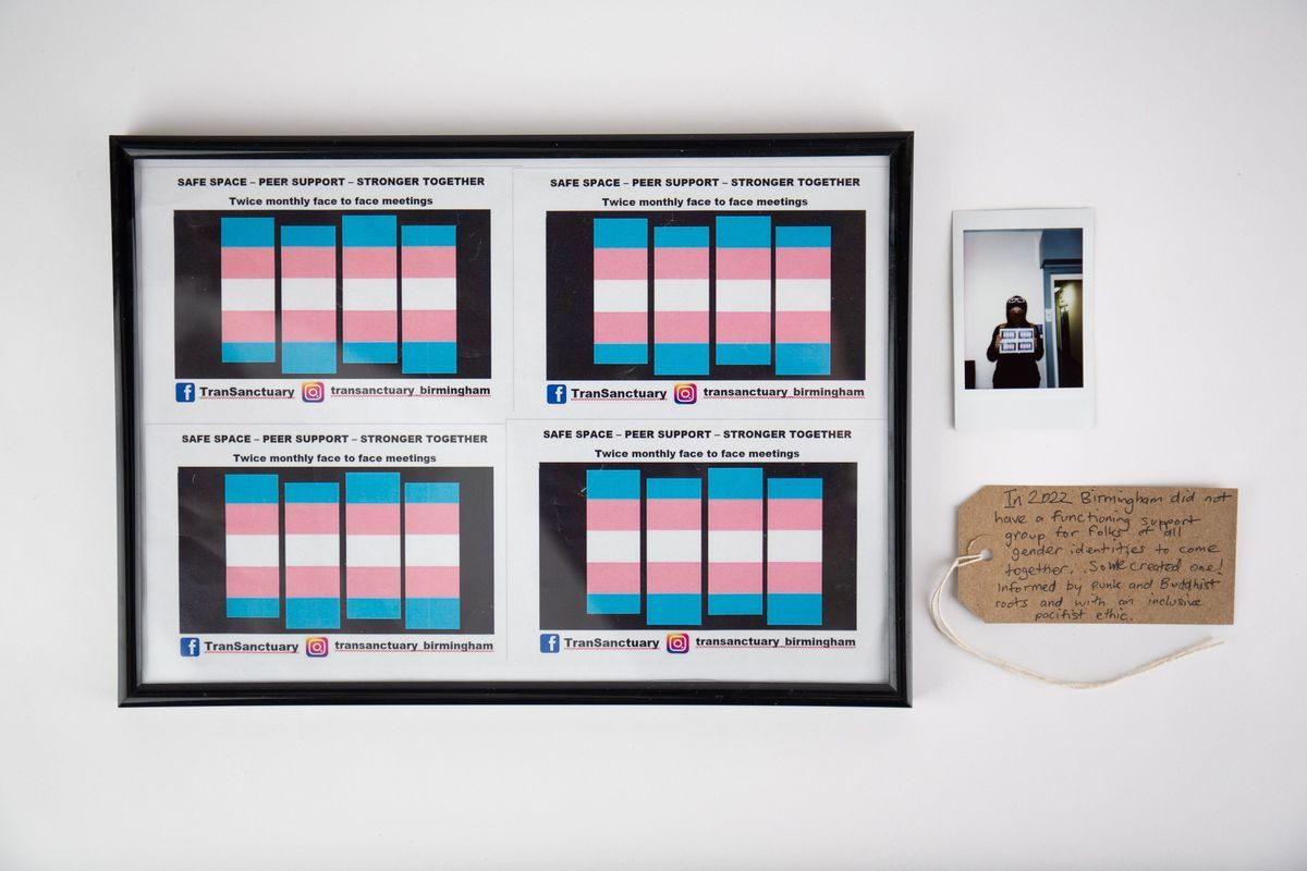Four copies of TranSanctuary flyer drafts in a black frame, next to the associated polaroid and tag.