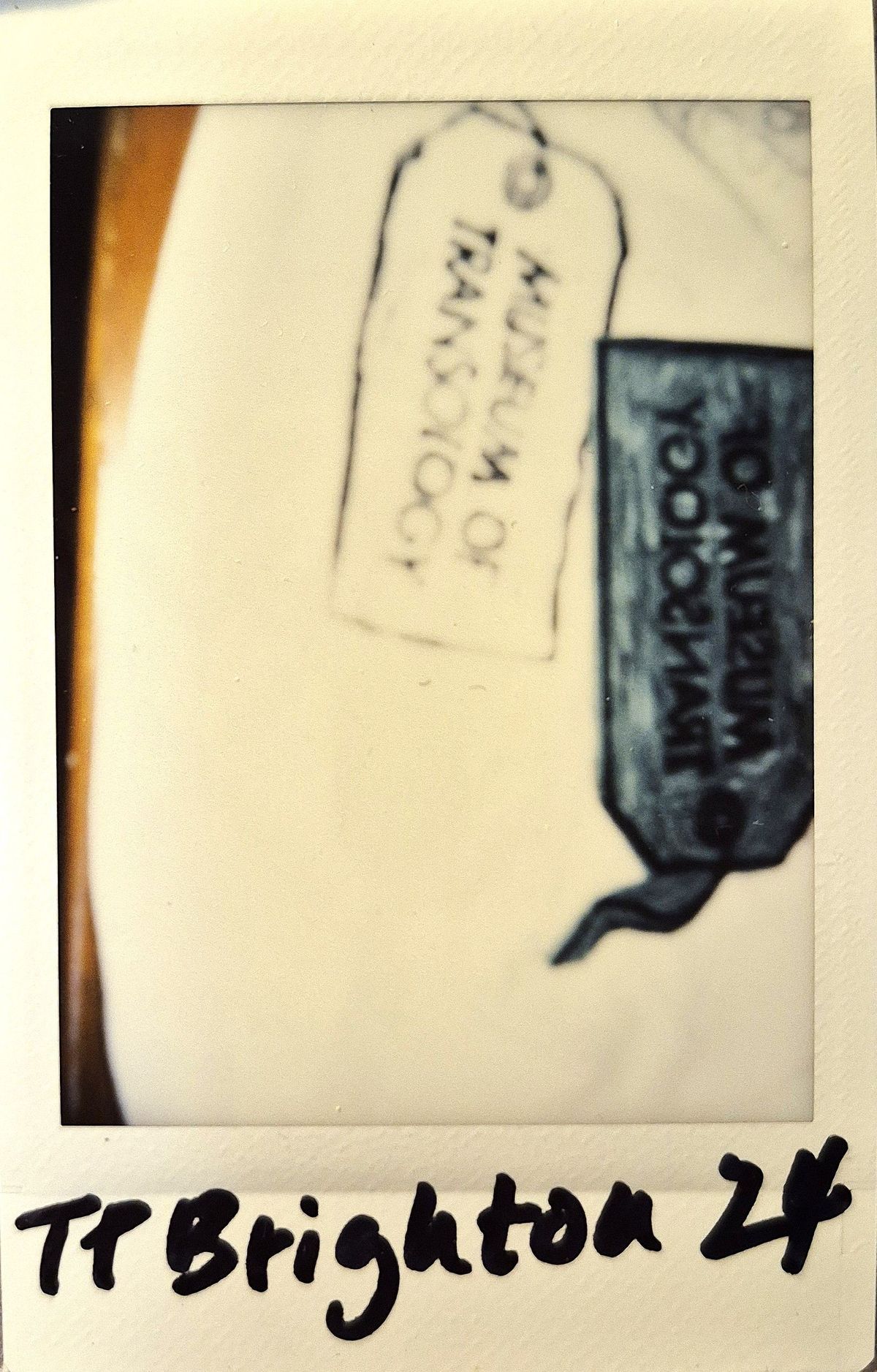 A blurry photograph where you can just about make out a few graphics of a tag which says 'Museum of Transology".