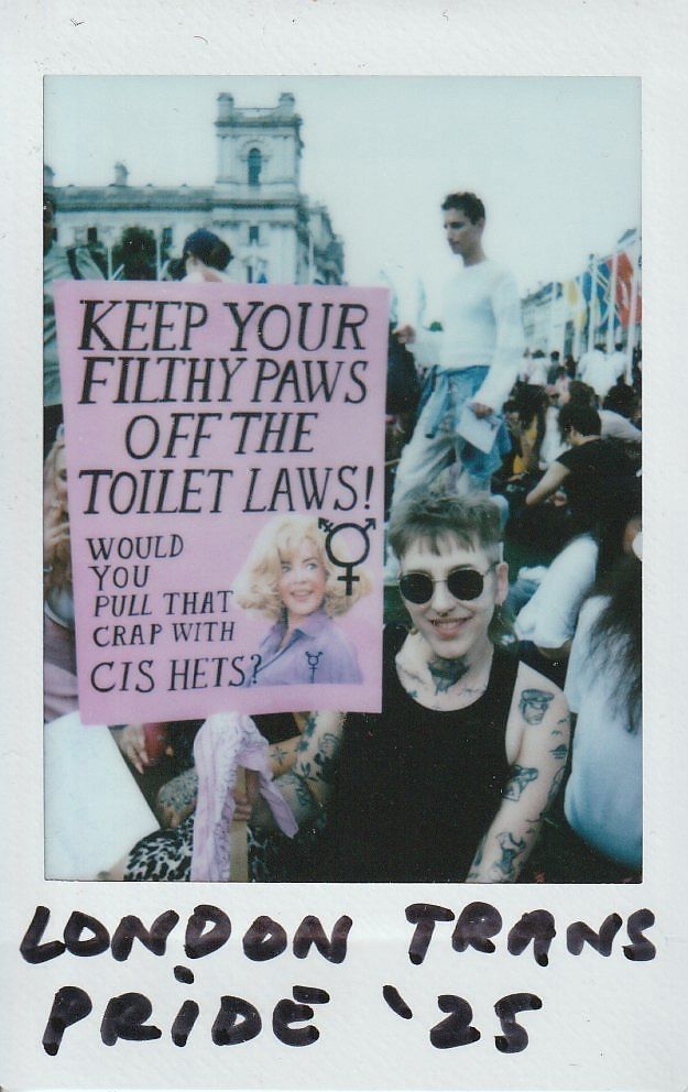 A person holding a placard which says "Keep Your Filthy Paws Off The Toilet Laws".