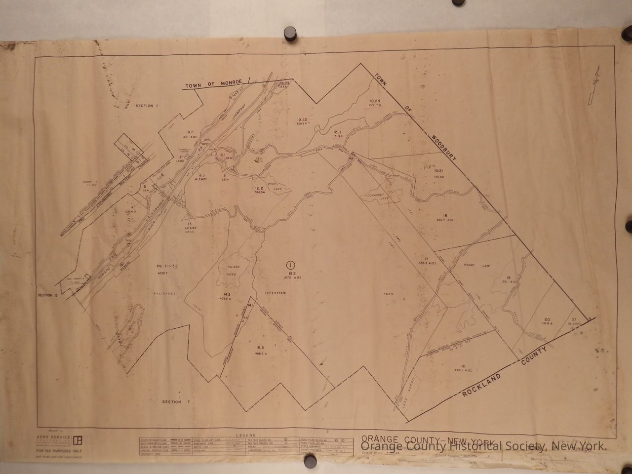 Tuxedo (Arden) Orange County, Section 6 Tax Parcel Map, 1973: The image depicts a 1973 tax map of Section 6 of the Town of Tuxedo, Orange County, New York, highlighting areas such as the Town of Monroe and the Town of Woodbury. It shows geographical features, roads, and property divisions in a detailed manner with labels and markings, bordered by Rockland County and the Town of Tuxedo. The map has a weathered appearance, with visible pinholes at the corners, and serves as a historical reference for land use and ownership, produced by Aero Service Corporation for tax purposes.