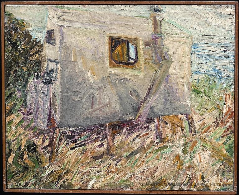 Dune shack in sea grass and ocean in the distance