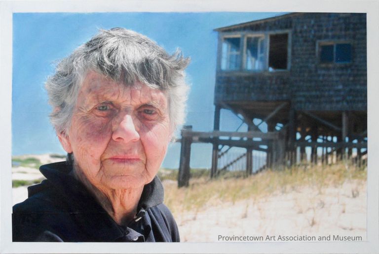 Portrait of old woman in front of dune shack with blue sky background