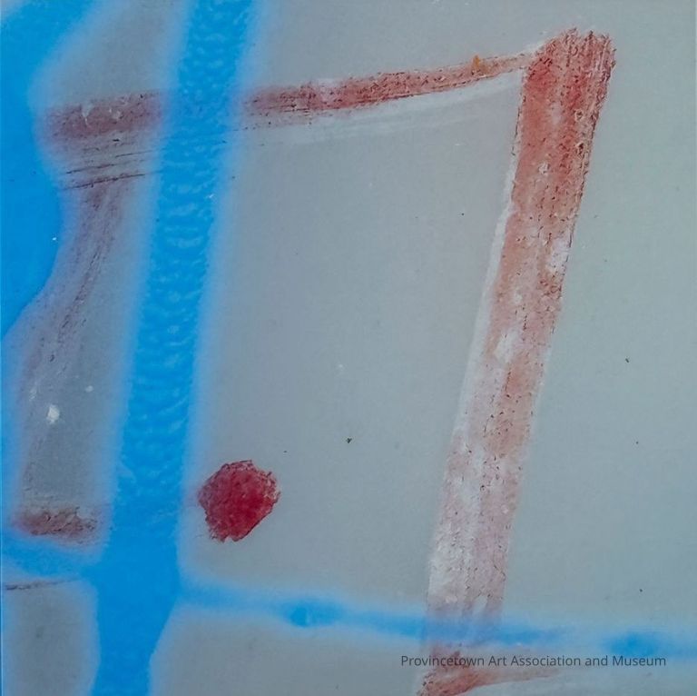 Photograph of red and blue streaks of spray paint crossing on a gray wall. A dot of red paint in the lower left.