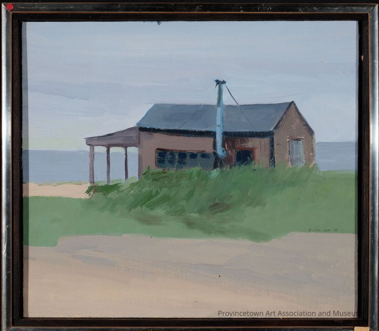 Brown shack in dune landscape with blue sky and water in the background