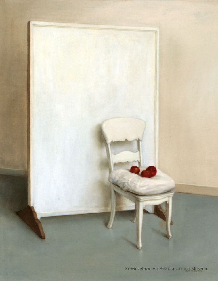 Three red apples on white chair, in front of white screen