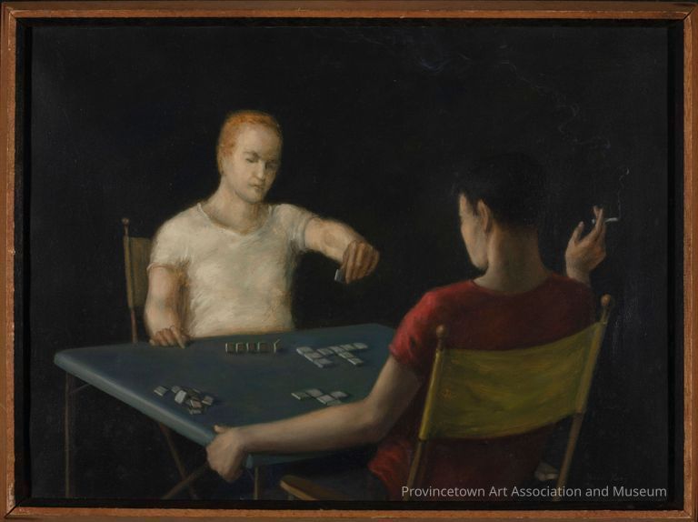 Two men sit across from each other playing anagrams at a square table. They sit in yellow director chairs. The dark haired player, with his back to the viewer, has a cigarette in his right hand.