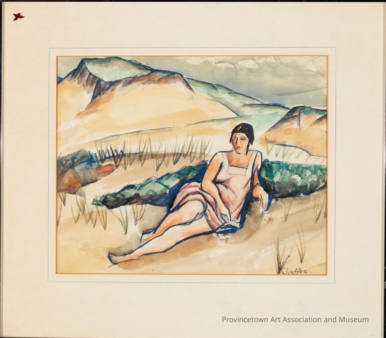 Woman wearing dress lying down in dune landscape