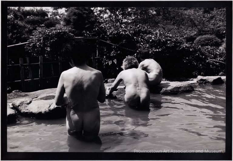 Nude women bathing outside, seen from behind