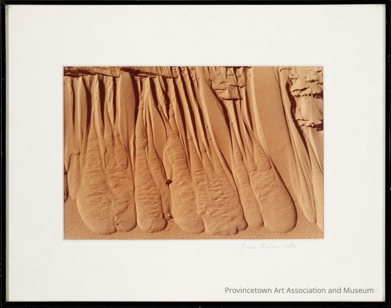 Intriguing pattern of erosion in sand, resembling flowing drapes